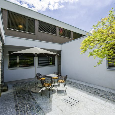 Eine Terrasse mit Stühlen und Sonnenschirmen