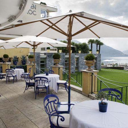 Schirme auf Terrasse mit Ausblick über Tischen und Stühlen