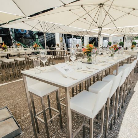 Schirme über weißen, gedeckten Tischen