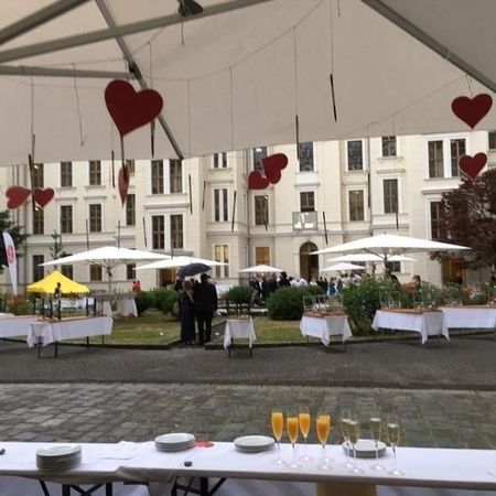 Ein Tisch mit weißen Tischdecken und Sonnenschirmen, ideal für eine elegante Outdoor-Veranstaltung